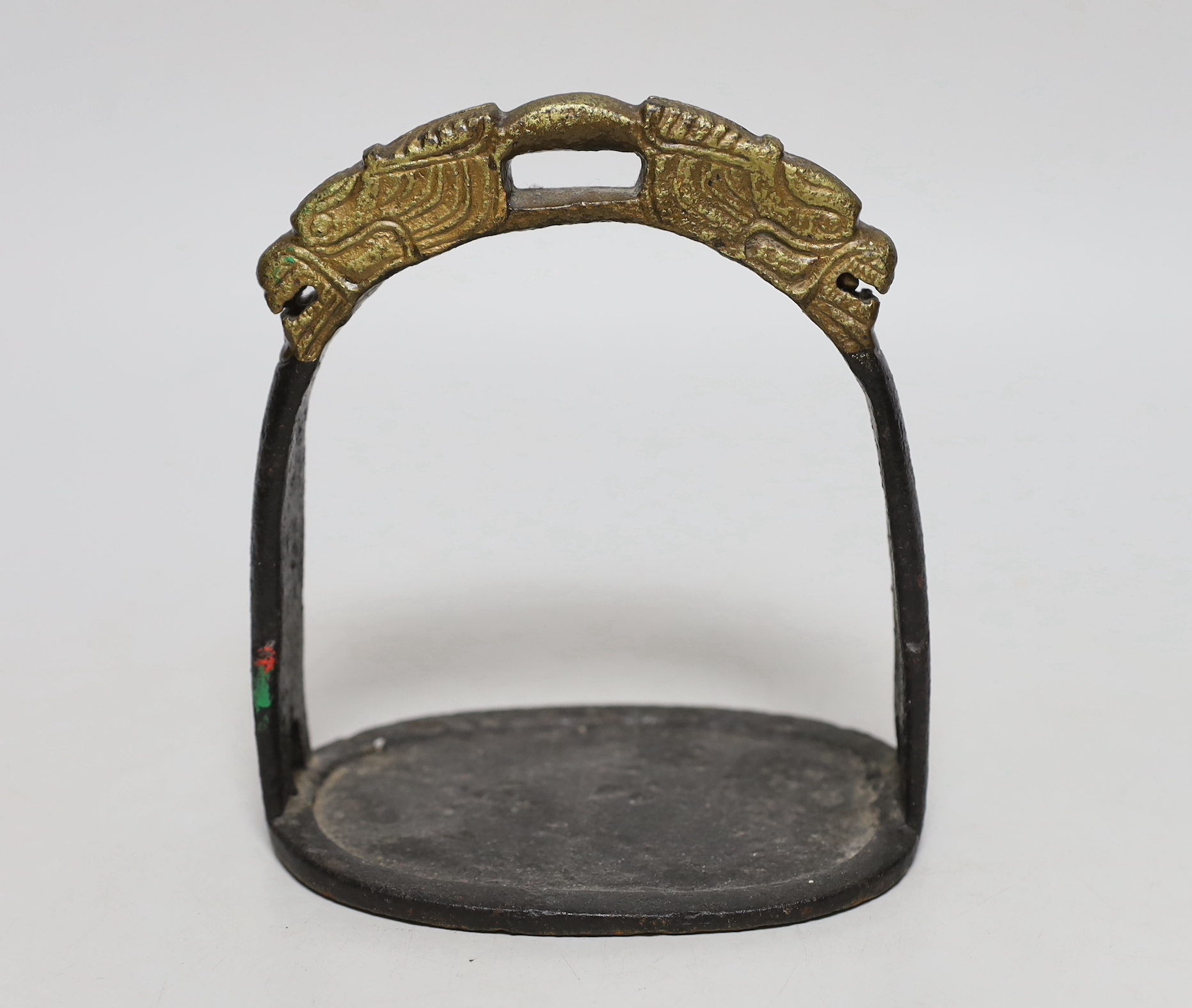 A Chinese cast iron stirrup, with dragon decoration, 16cm high